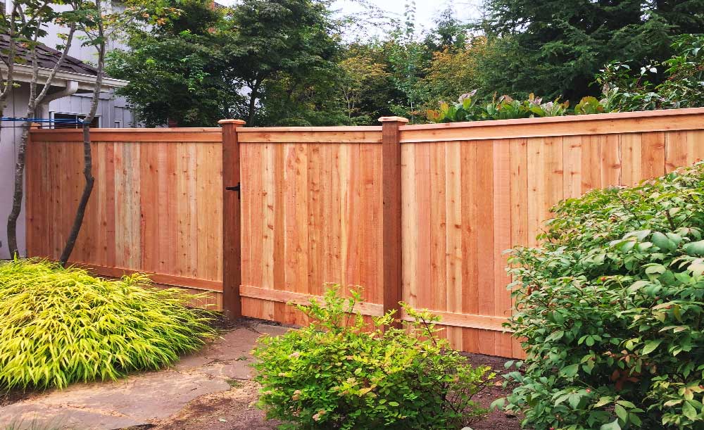 Modified Panel style cedar fence with extra trim on the bottom and gate