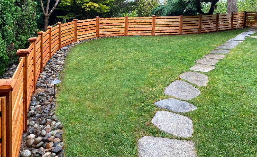 Horizontal style cedar fence with space and alternating boards