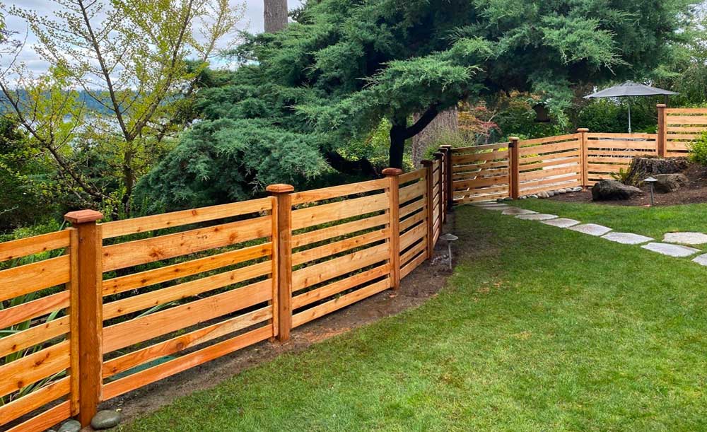 Horizontal style cedar fence with space and alternating boards